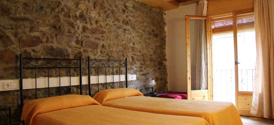 Photo de l'intérieur d'une chambre avec deux lits simples et une fenêtre